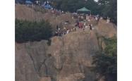 大连一跨海大桥观景台有游客翻栏杆踩空心造景石拍照，当地回应